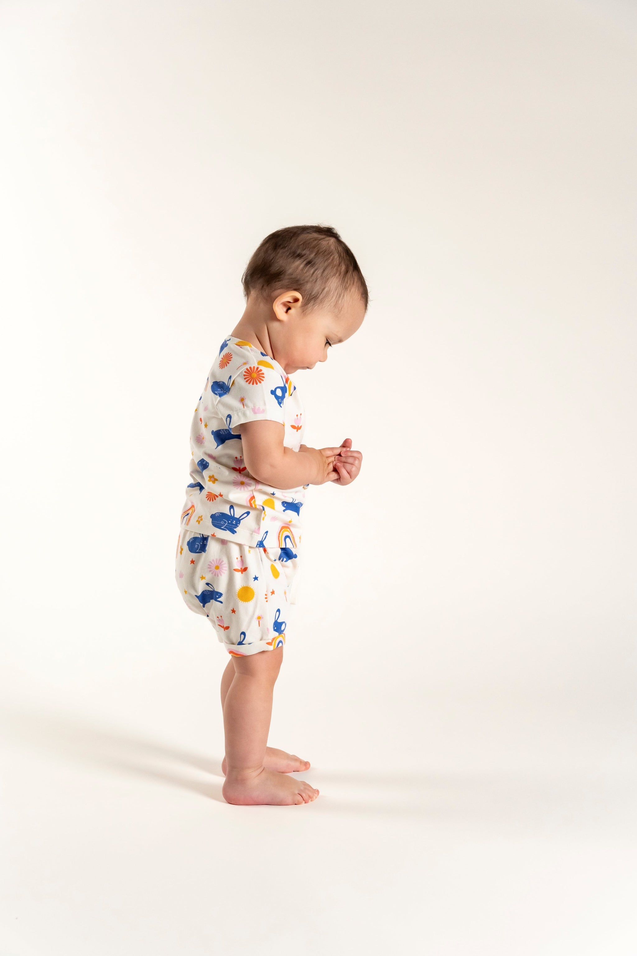 Adorable toddler girl wearing slouchy shorts with bunnies and rainbow print, perfect for comfortable and stylish everyday wear.