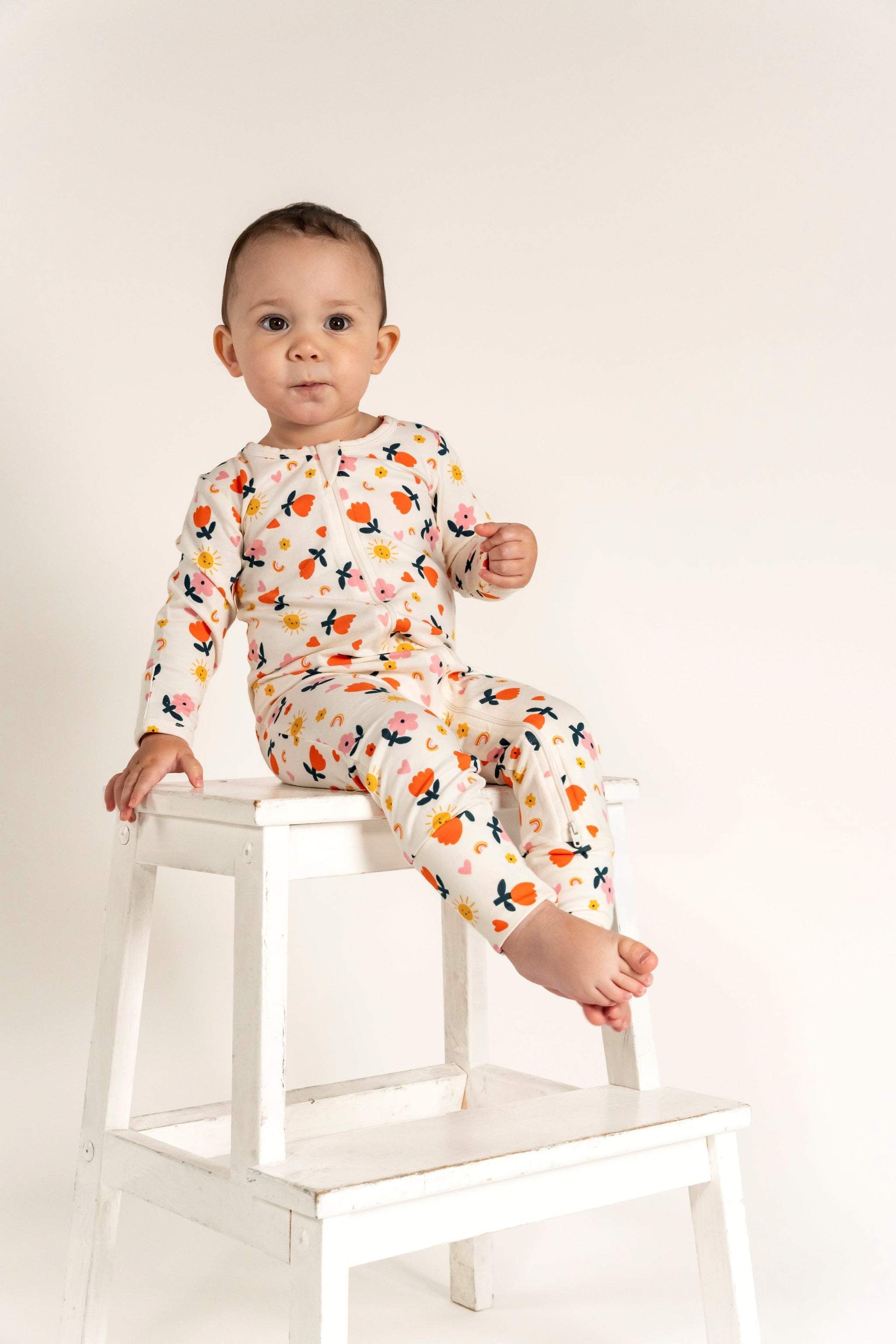 Toddler Girl Long Sleeve Zip Growsuit with vibrant Sunny Flower Print, crafted from soft, breathable fabric. Features a convenient front zipper for easy changes, perfect for playful and cozy days.