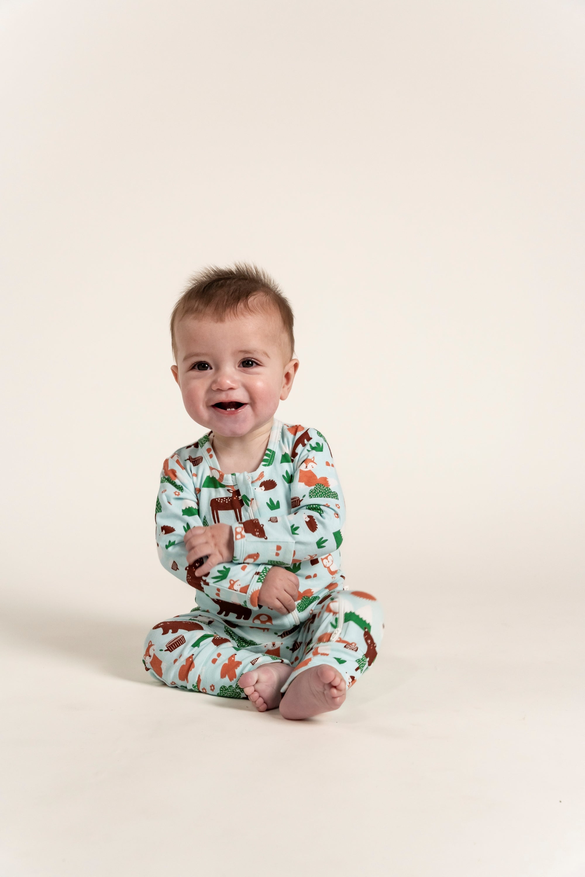 Toddler Boy Long Sleeve Zip Growsuit - Forest Animal Print, featuring playful forest animals in shades of green, brown, and orange on a light blue background, ideal for cozy and comfortable wear.