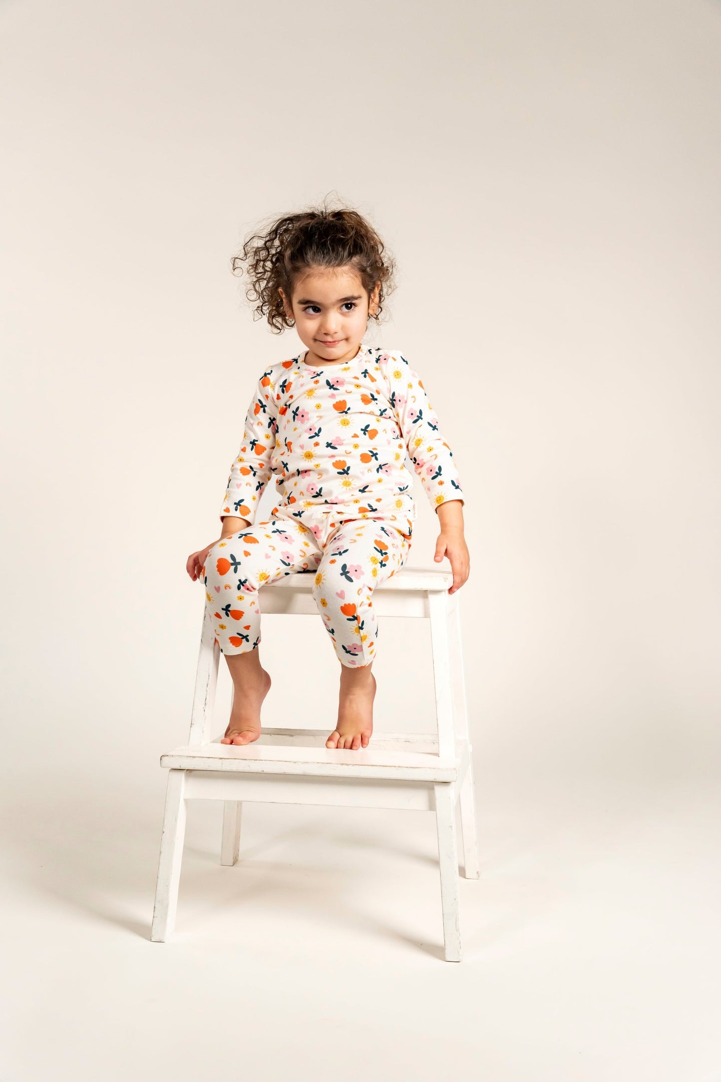 Toddler Girl Long Sleeve T-shirt and Pants Set - Sunny Flower Print. Featuring vibrant floral designs with cheerful sun and heart motifs on a cream background. Comfortable and stylish outfit.