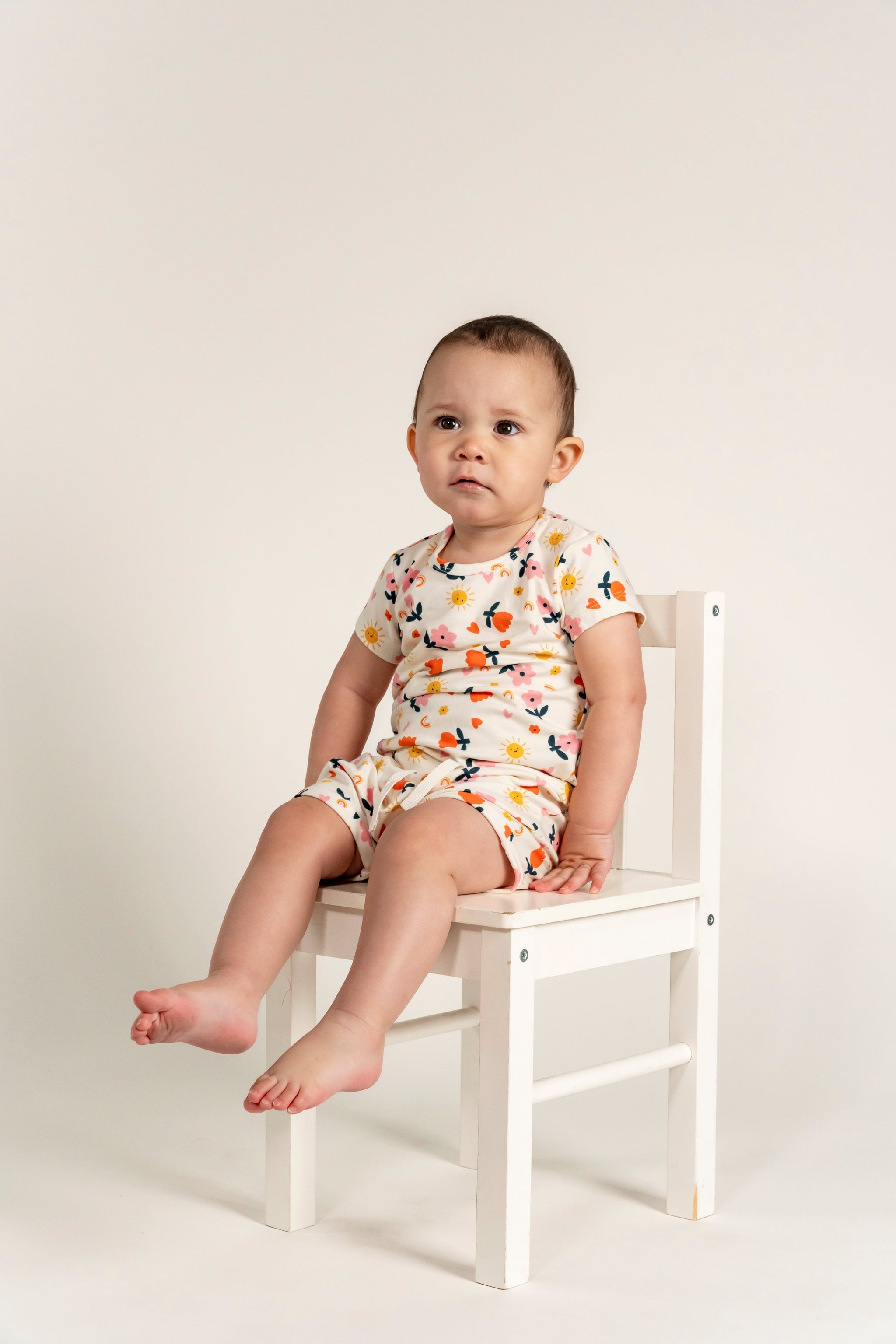 Toddler girl wearing slouchy shorts with a sunny flower print, offering a cute and comfortable outfit perfect for warm weather days.